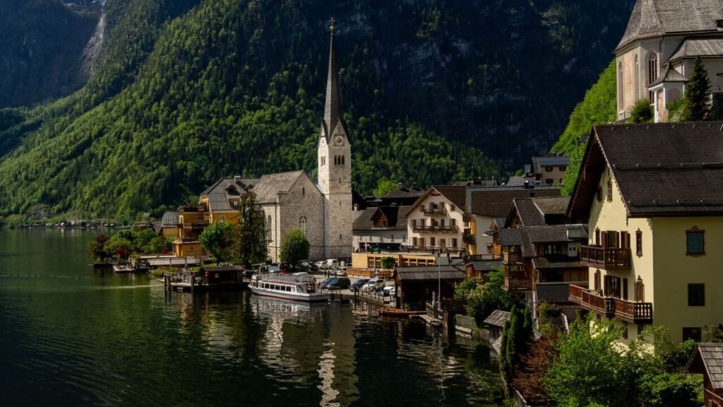 Charming view of Hallstatt with its iconic church by the lake against a backdrop of mountains.